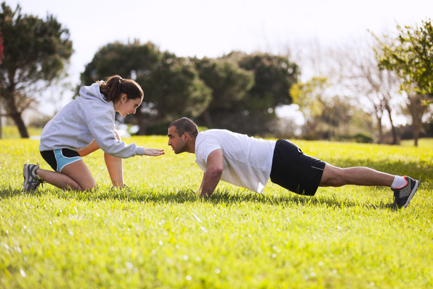Trainer coaching a client through push-ups